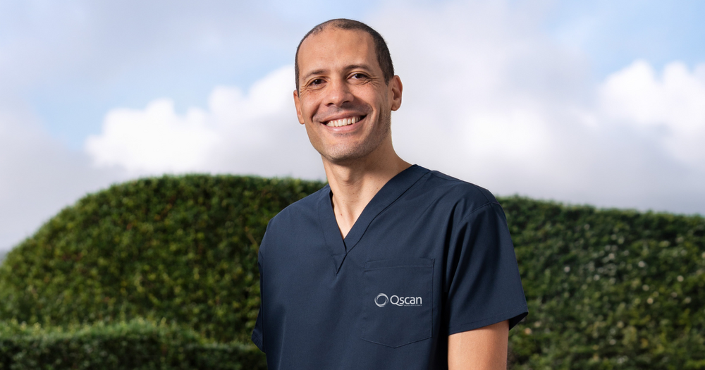 Dr Jeff, a Qscan radiologist, in Qscan navy scrubs smiling to camera. 