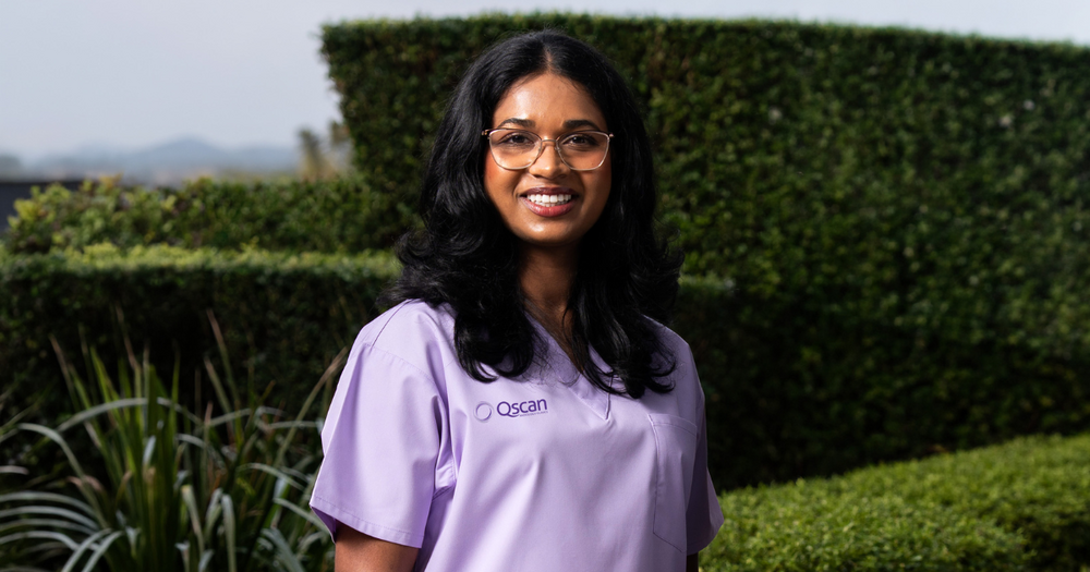 Dr Shanalie, a Qscan radiologist, in Qscan purple scrubs smiling to camera. 